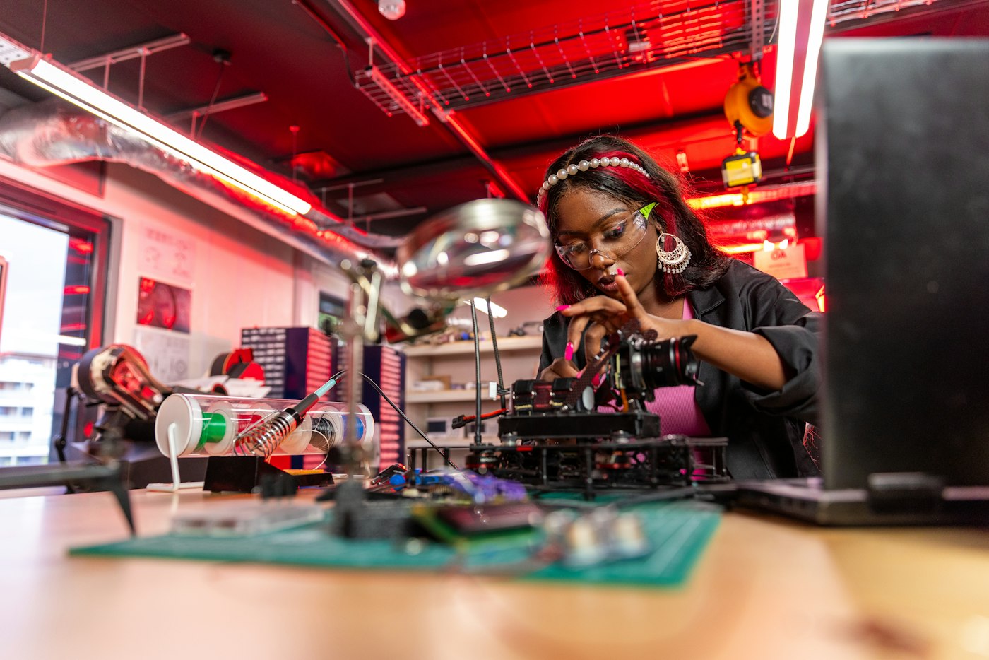 A student assembling a robot at a workbench in an engineering lab
